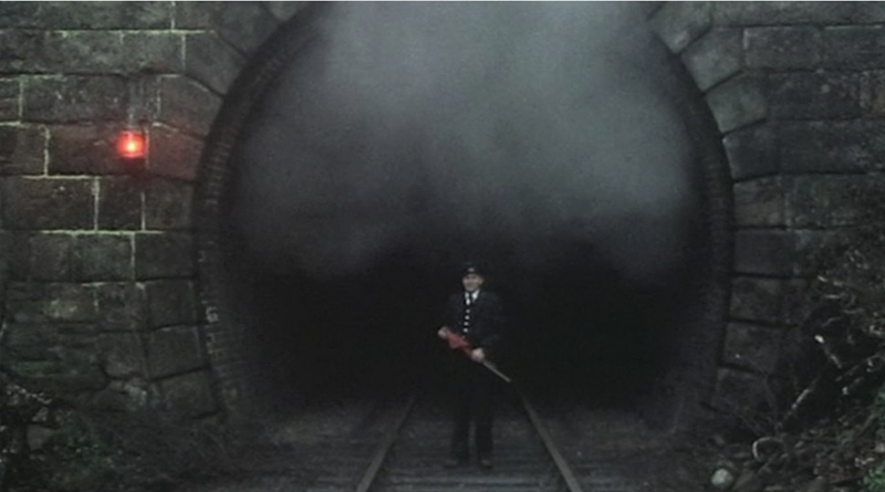 The Signalman stands at the tunnel entrance